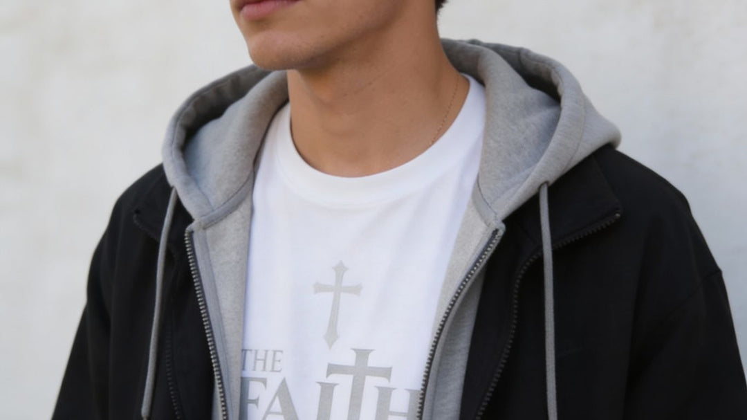 A person wearing a white t-shirt with a cross and text.